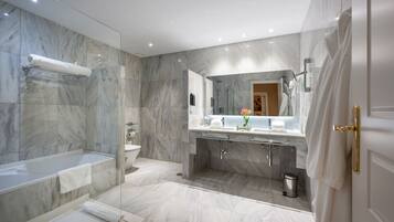 Une salle de bain moderne avec une douche à parois de verre, un grand miroir et un sol en marbre.