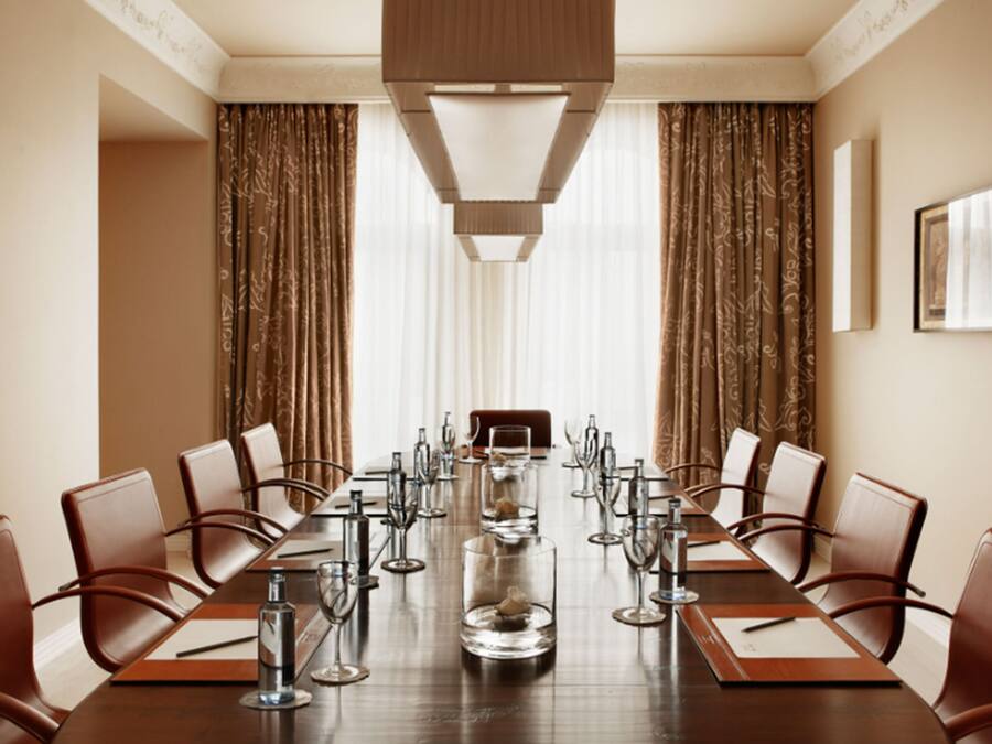 A conference room with a long table, chairs, and a chandelier.