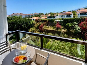 A balcony with a table set for breakfast, overlooking a residential area with houses and lush greenery. - Hotel Perla Tenerife (Puerto de la Cruz)