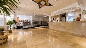 A lobby with a marble floor, a reception desk, and a staircase with a railing. - Hotel Perla Tenerife (Puerto de la Cruz)