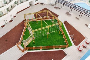 An indoor playground with a climbing structure, seating areas, and a pool. - Alua Atlantico Golf (San Miguel de Abona)
