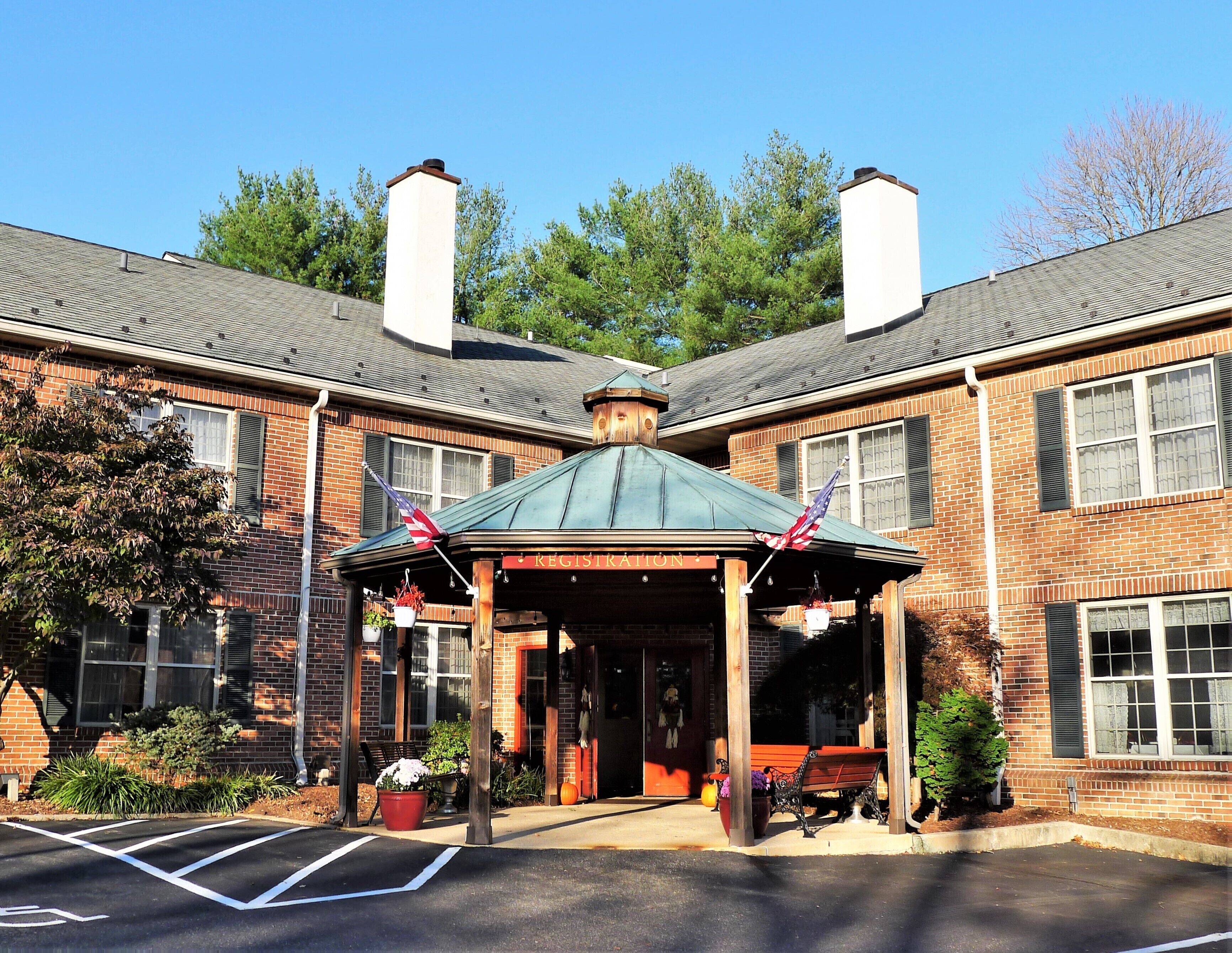 A brick building with a covered entrance and two chimneys.