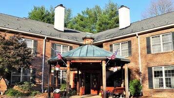 A brick building with a covered entrance and two chimneys.