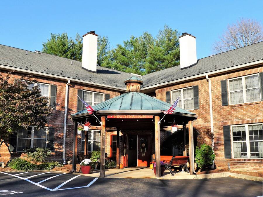 A brick building with a covered entrance and two chimneys.