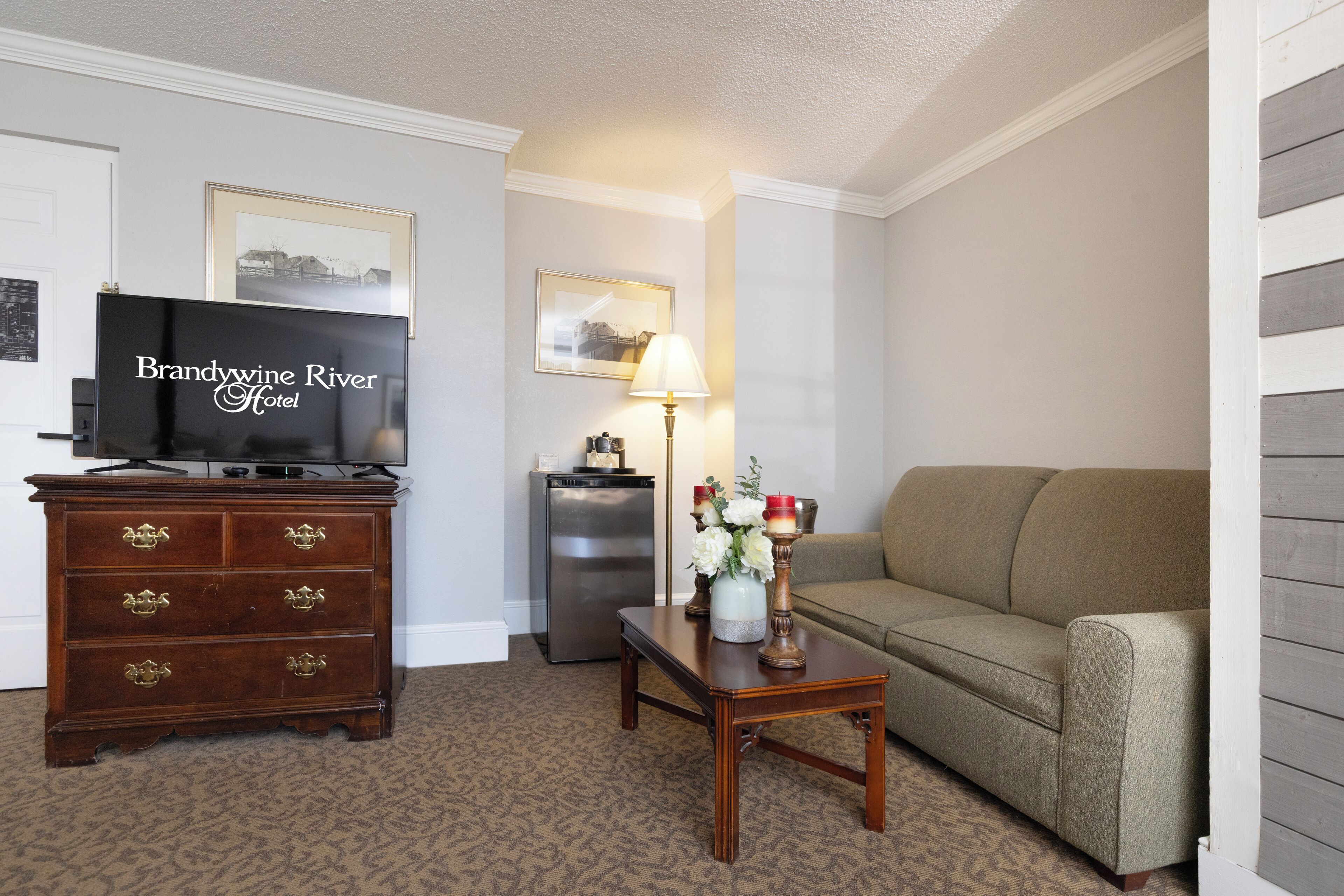 A living room with a television, a dresser, a lamp, and a sofa.