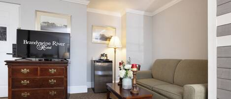 A living room with a television, a dresser, a lamp, and a sofa.