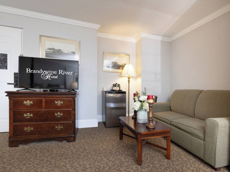 A living room with a television, a dresser, a lamp, and a sofa.