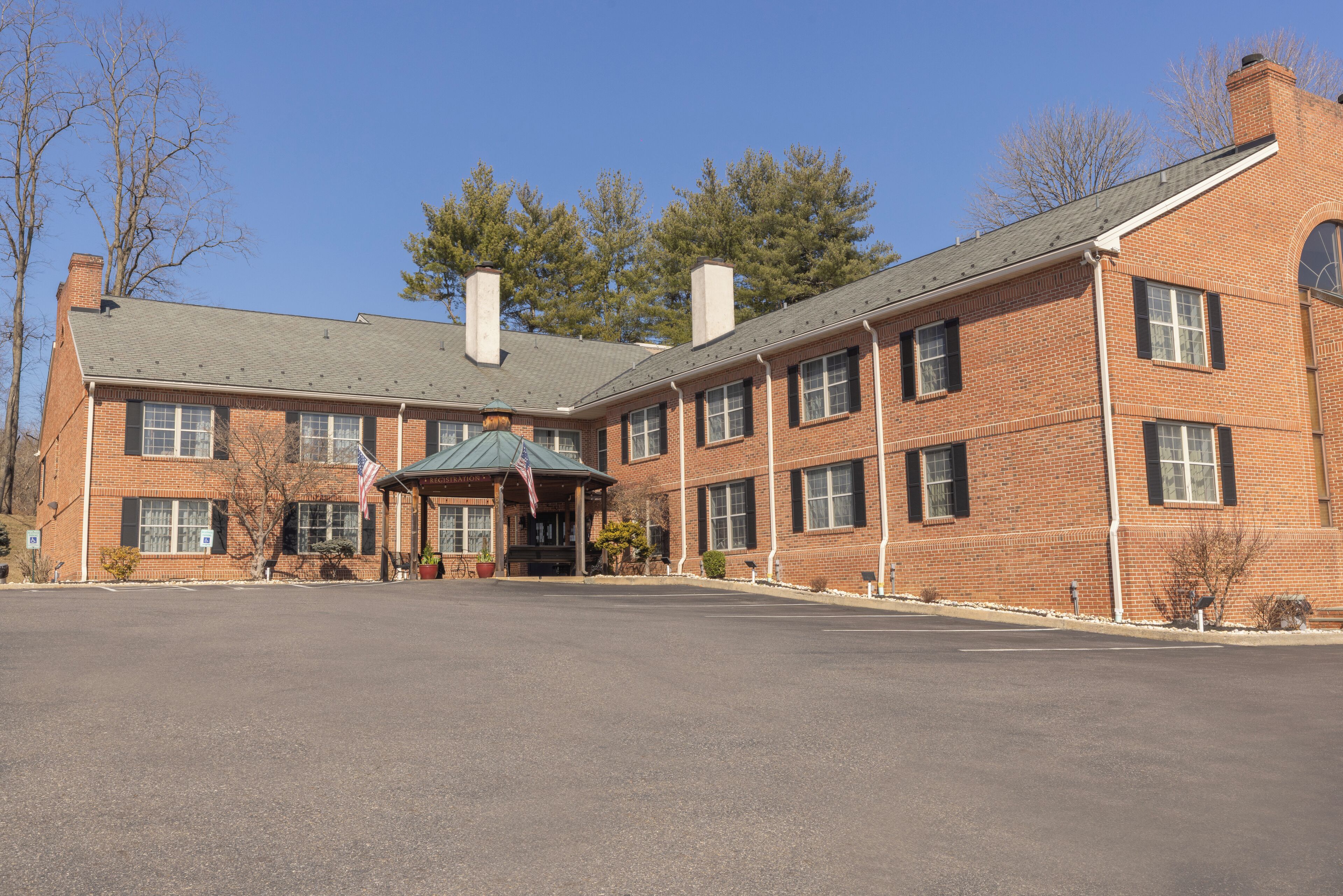 A brick building with a covered entrance and multiple windows.