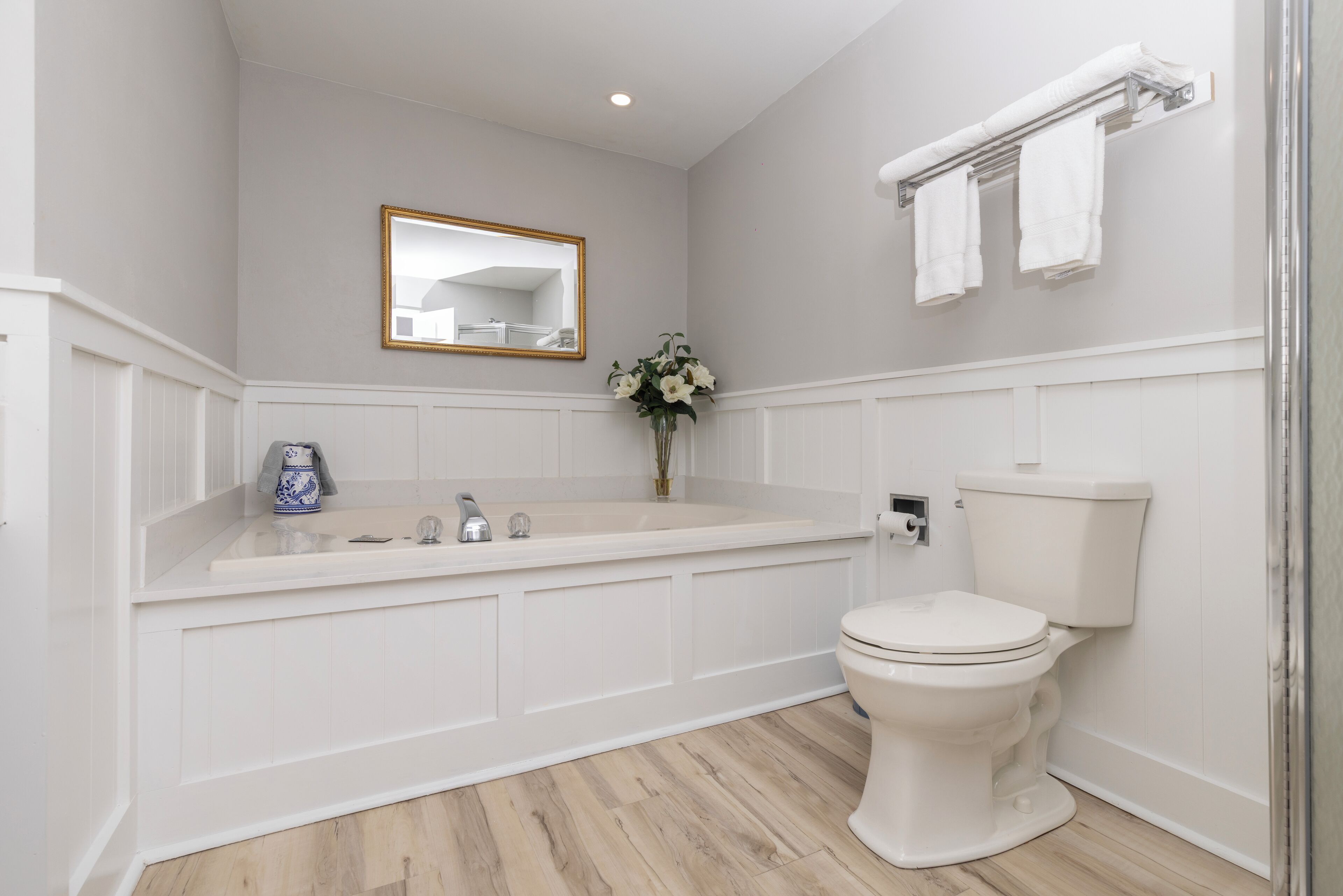 Un baño con una bañera blanca, un inodoro, un lavabo y un espejo.