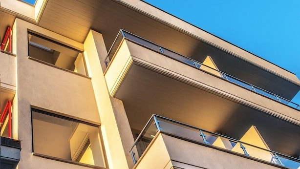 Un edificio moderno con varios balcones y grandes ventanales.