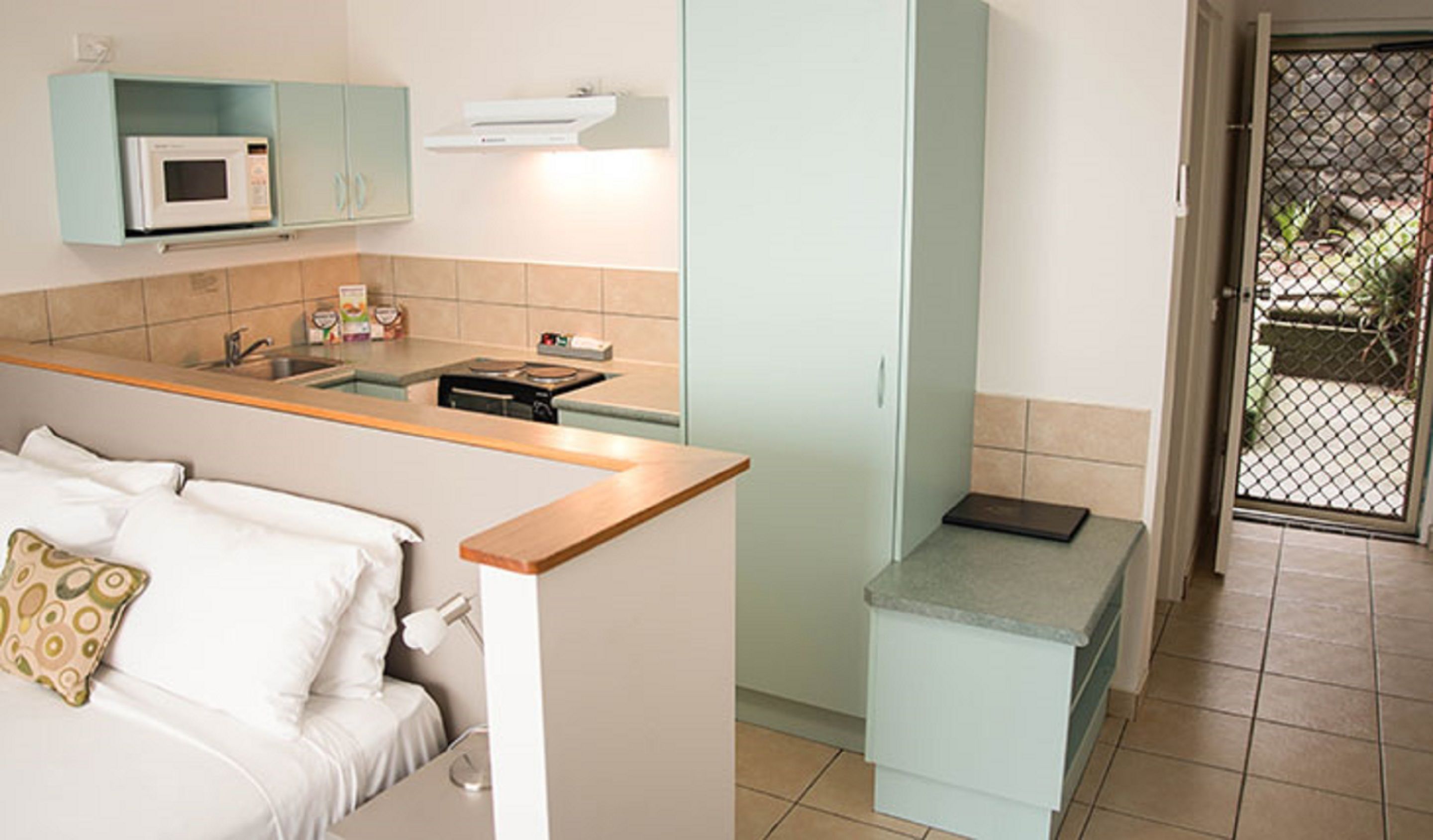 A compact kitchen with a microwave, sink, and a small countertop.
