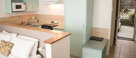 A compact kitchen with a microwave, sink, and a small countertop.