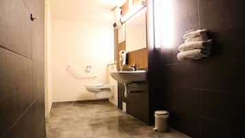 A small bathroom with a sink, mirror, towel rack, and toilet.