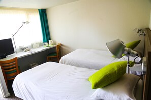 A hotel room with two beds, a desk with a computer, a chair, and a lamp. - Campanile Narbonne (Narbonne)