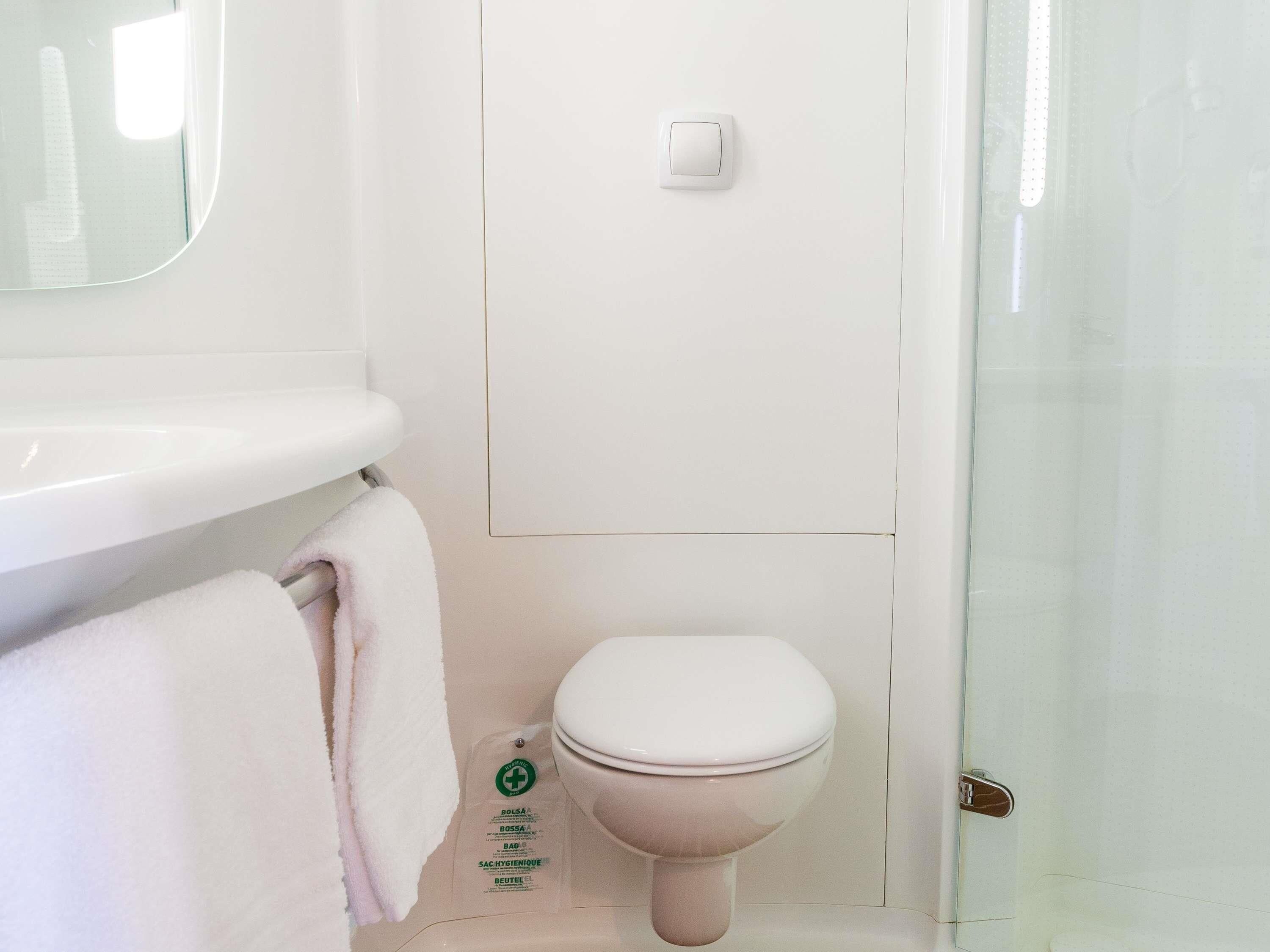 A bathroom with a toilet, a sink, and a mirror.