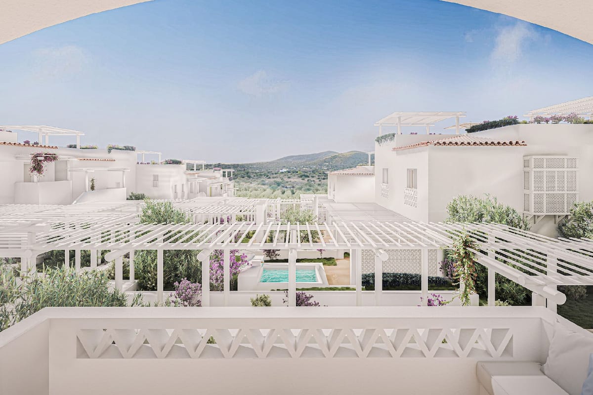 A rooftop terrace with a pool, white buildings, and a clear view of the landscape.