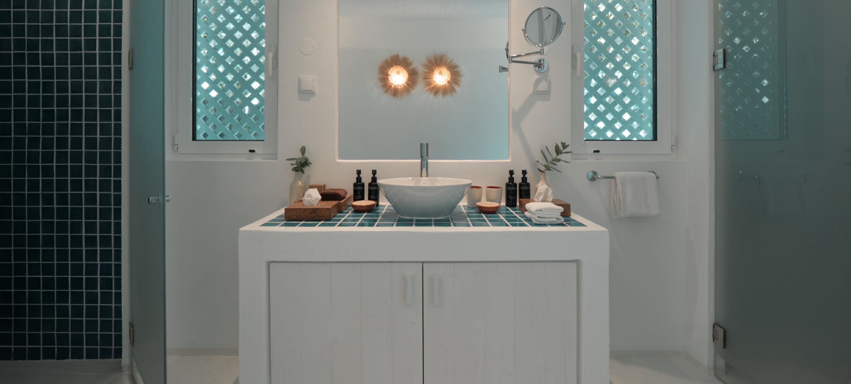 A bathroom with a white vanity, a large mirror, and two wall-mounted lights.