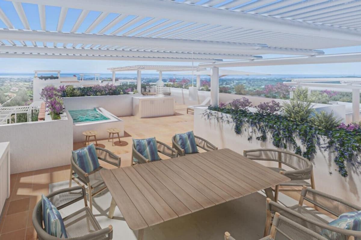 An outdoor patio with a wooden table and chairs, a pool, and a view of the landscape.