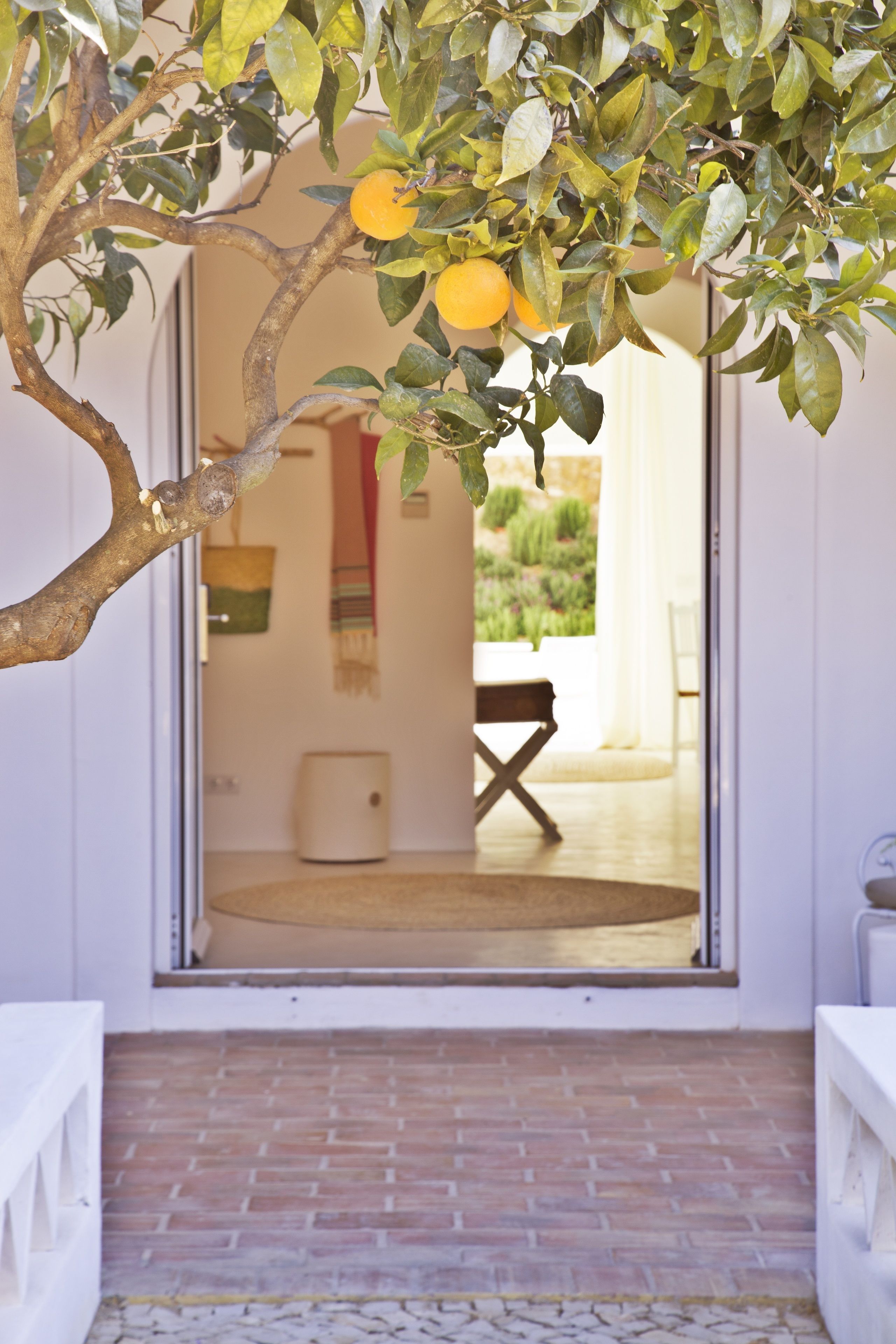 Una puerta que da a un cuarto con piso de baldosas y vistas al exterior.