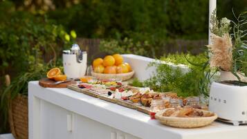 Una mesa de buffet con diferentes alimentos y un exprimidor de jugos.