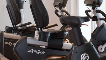 A row of stationary bikes with digital displays, likely in a gym or fitness center.