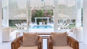 Una sala de estar moderna con vistas a una piscina y jardín.