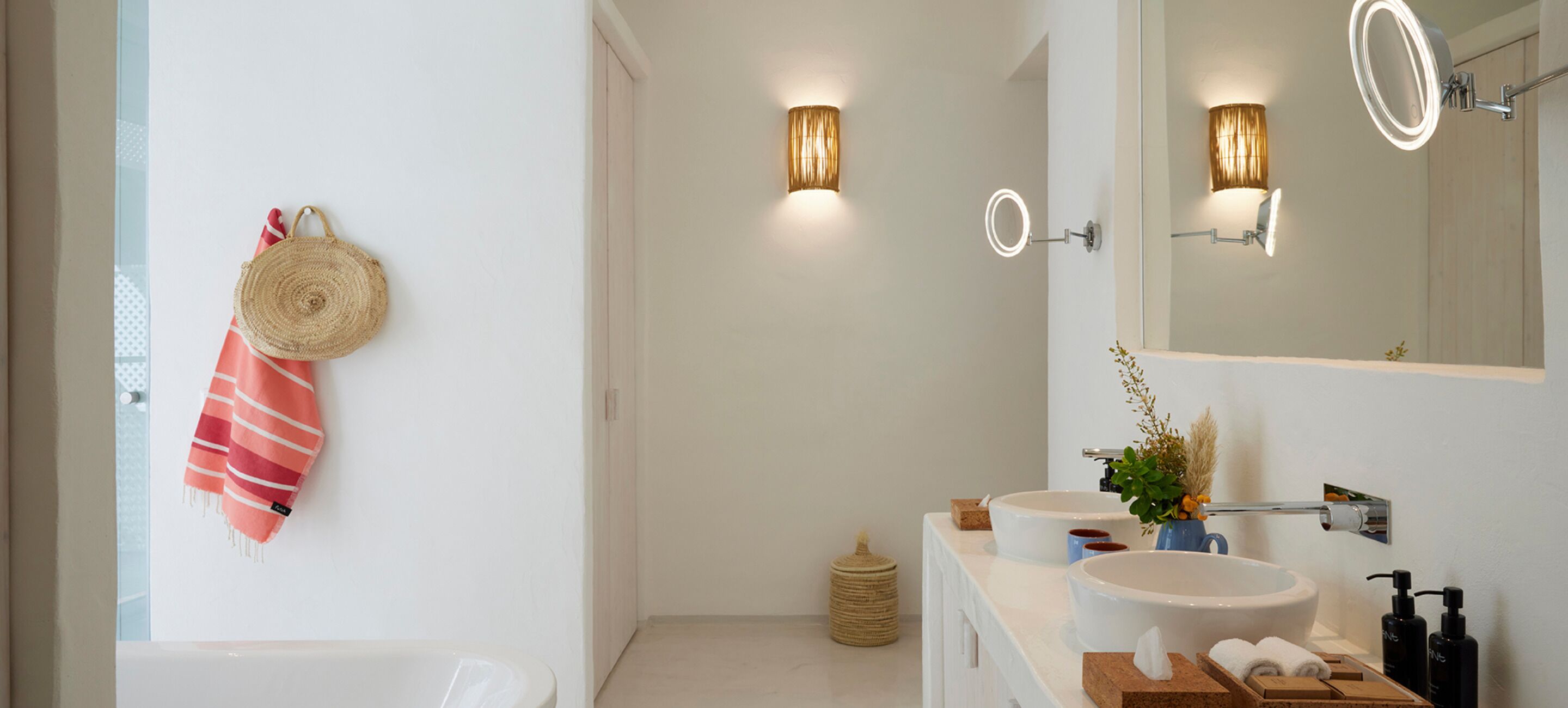 Un baño moderno con dos lavamanos, un espejo grande y un perchero para toallas.