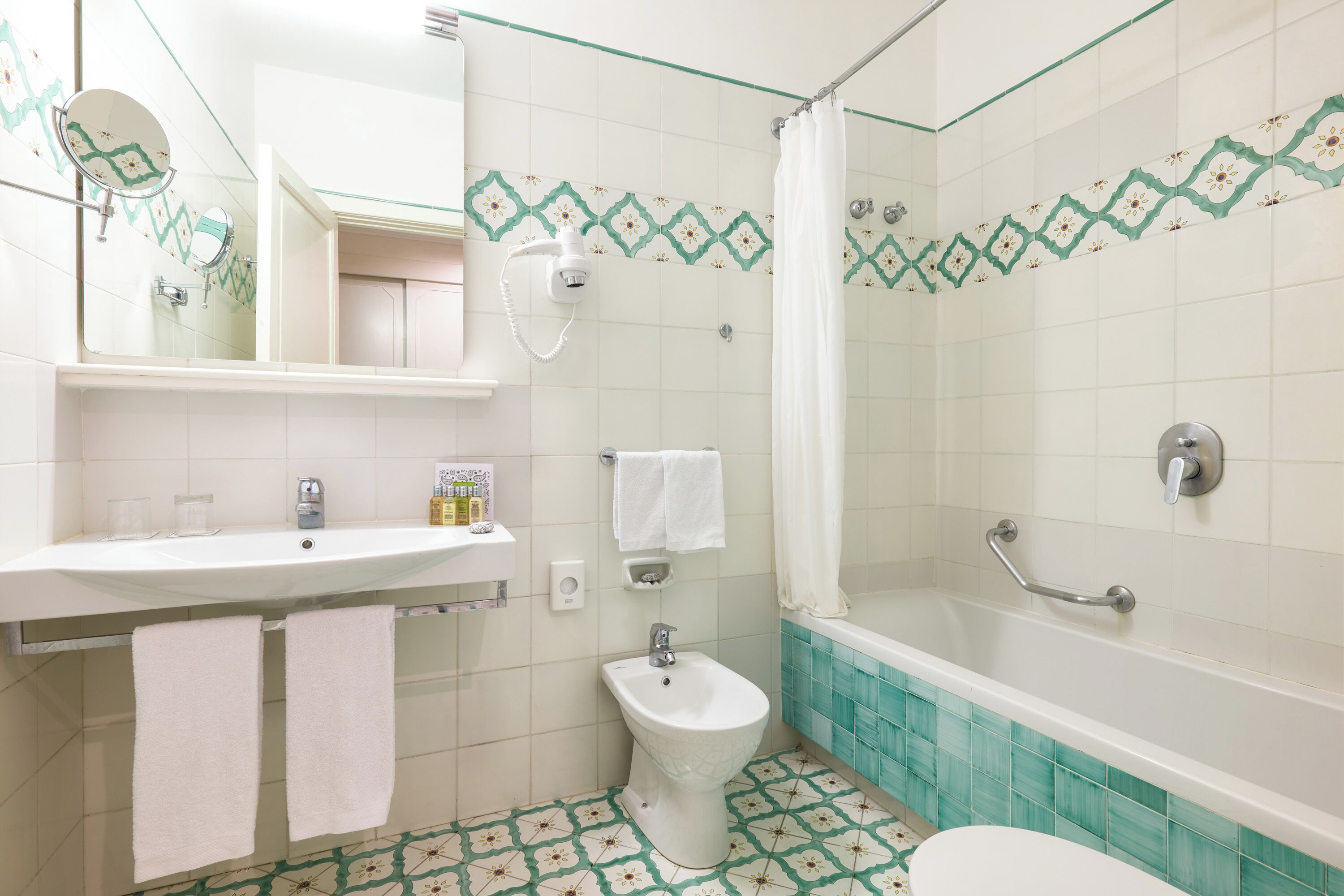 Un baño con lavamanos, bidé y bañera.