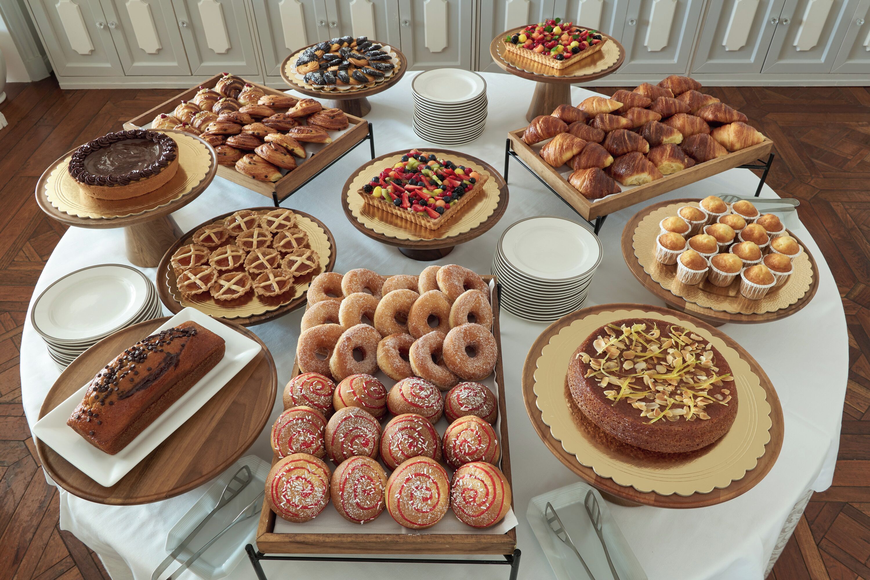 A buffet table with various baked goods and pastries.