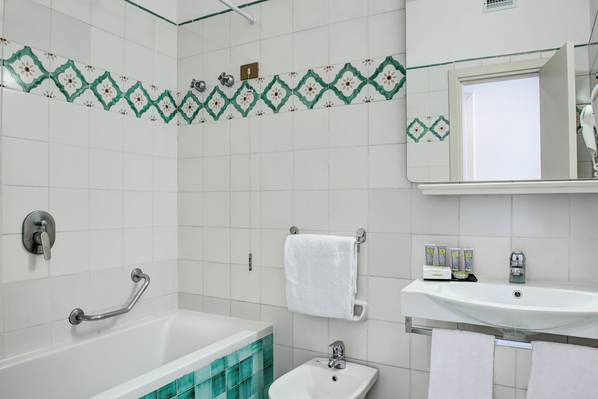 A bathroom with a bathtub, a sink, and a mirror.