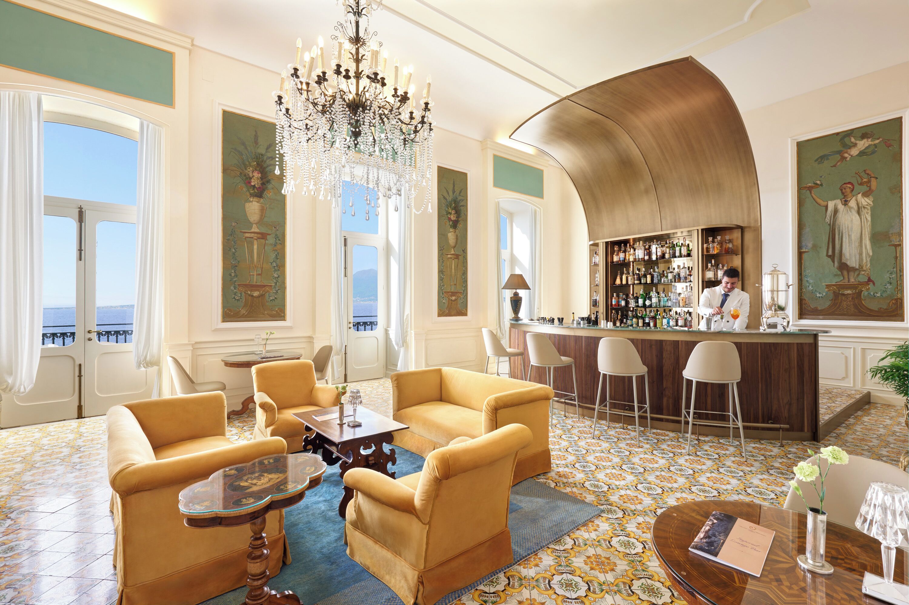 A hotel lobby with a bar, seating area, and large windows.