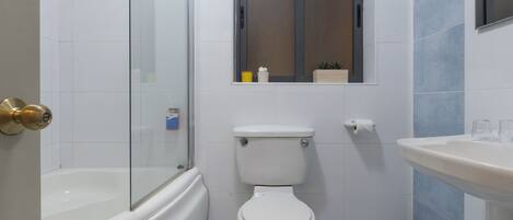 A bathroom with a bathtub, toilet, and sink.