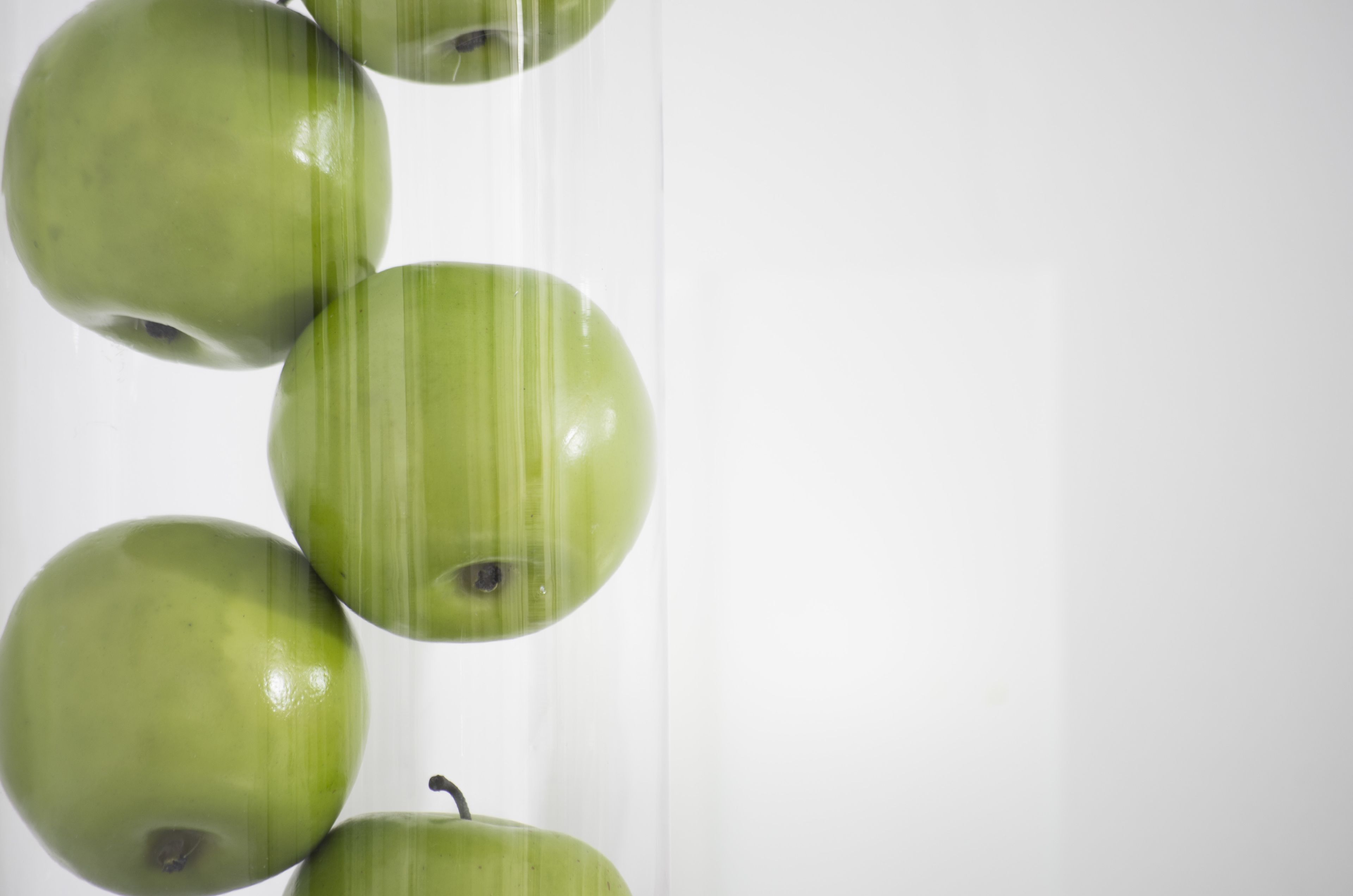 Varias manzanas verdes alineadas verticalmente.