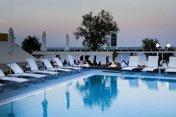 Piscine extérieure, parasols de plage, chaises longues