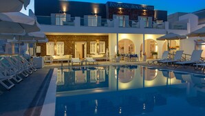 Una piscina al aire libre, sombrillas, tumbonas