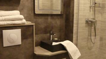 A bathroom with a toilet, sink, and shower.