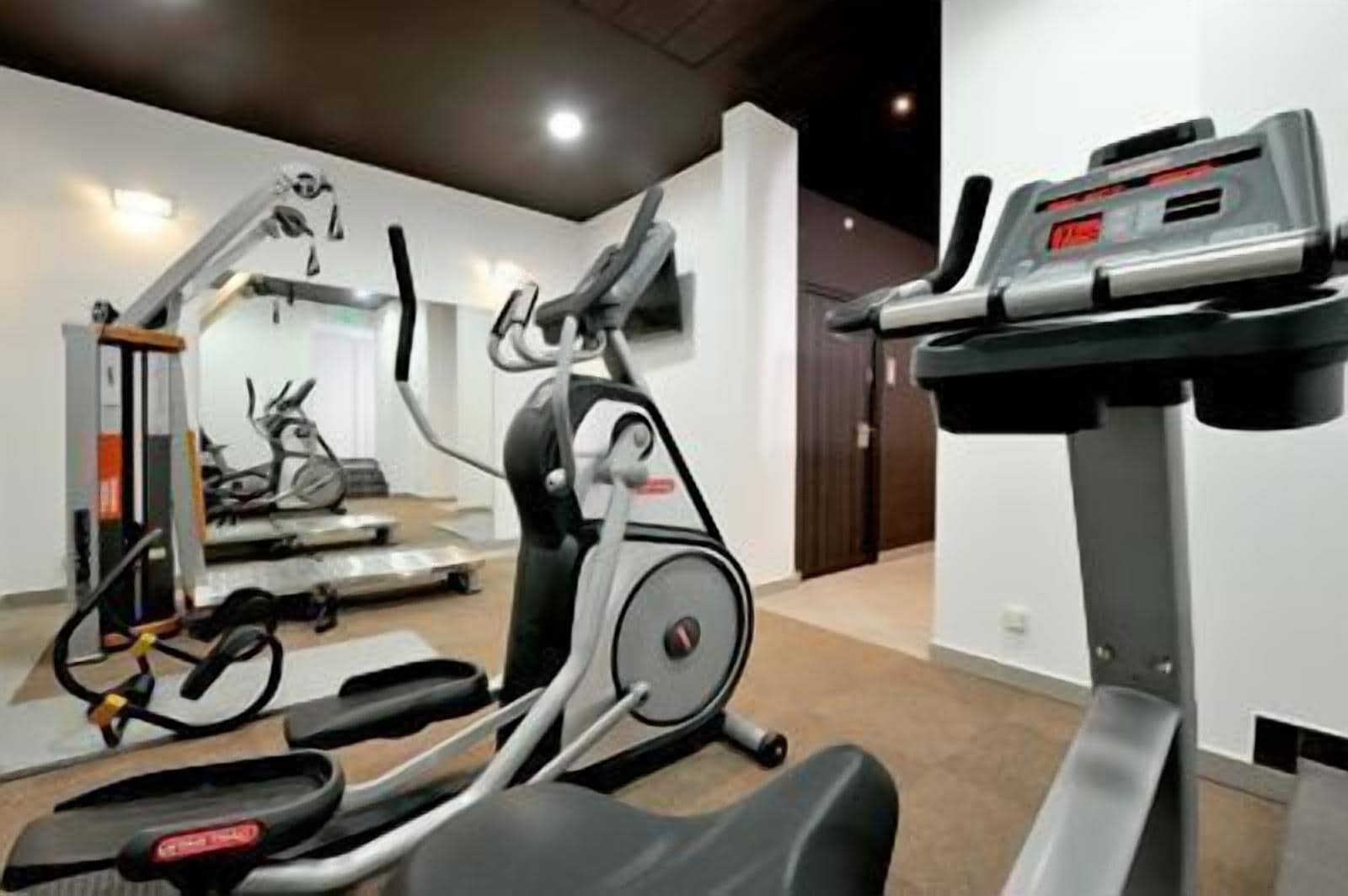 A home gym with a treadmill, stationary bike, and elliptical machine.