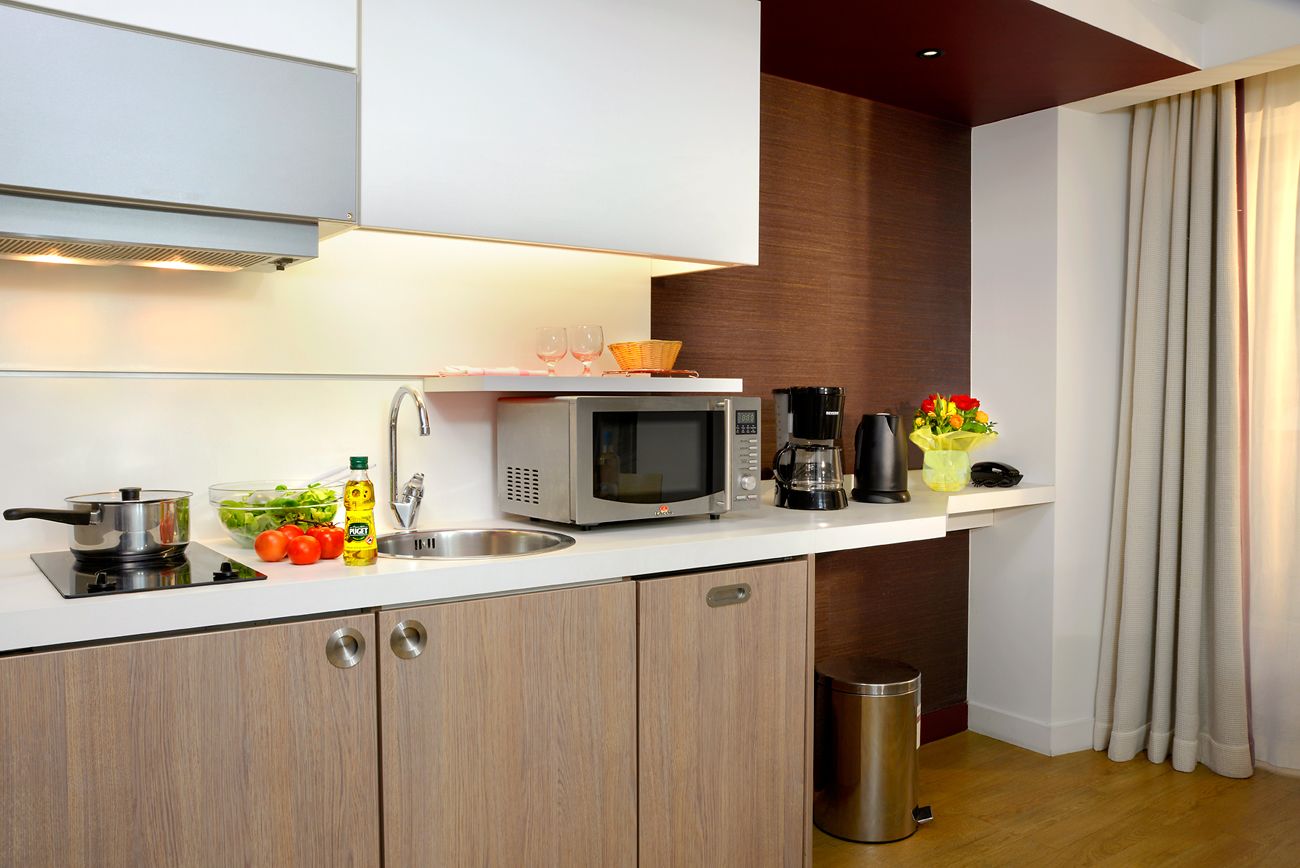 Eine moderne Küche mit Mikrowelle, Spüle und Holzschränken.