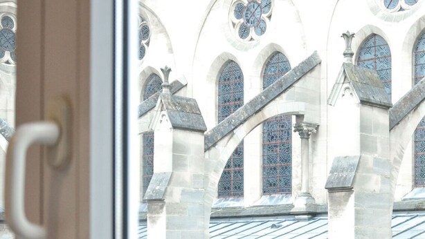 A view of a building with arched windows and stone columns. - Hôtel de la Perdrix Rouge (Paris)