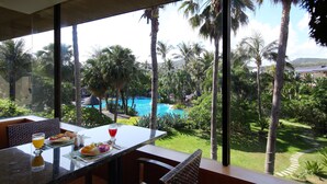 A dining area with a table and chairs, a glass of orange juice, and a plate of food. - Caesar Park Kenting (Hengchun)