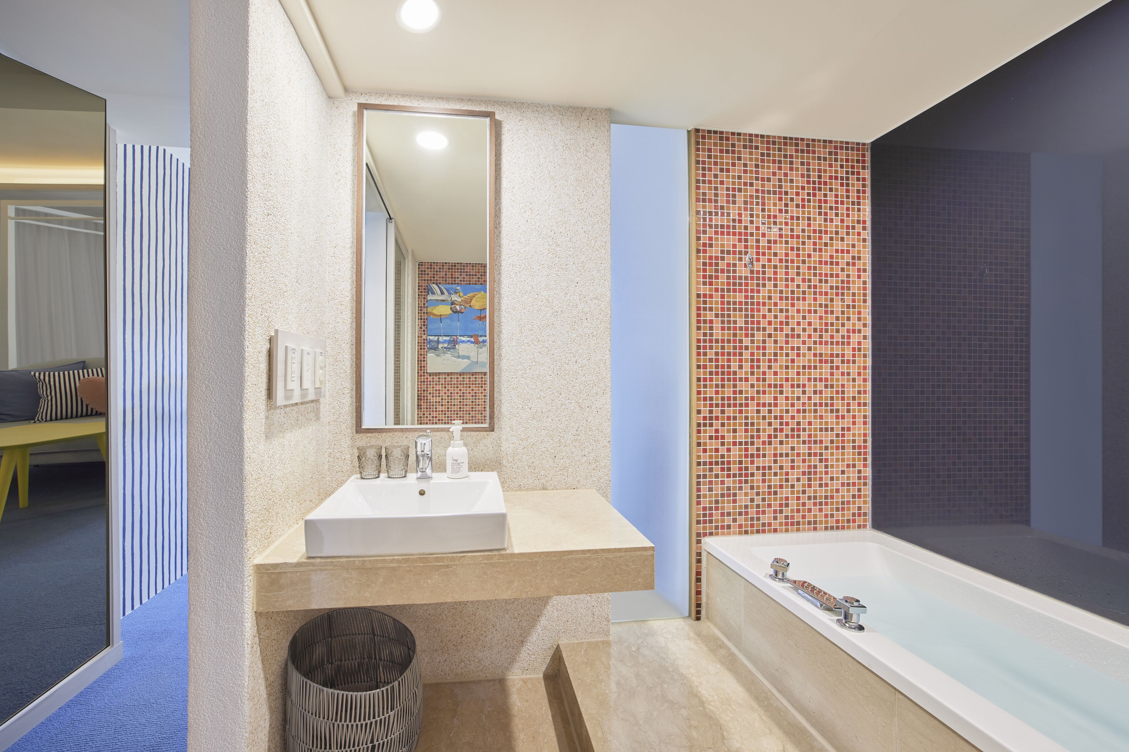 A modern bathroom with a large bathtub, a sink, and a mirror.
