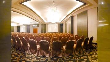 A conference room with rows of chairs facing a projection screen.