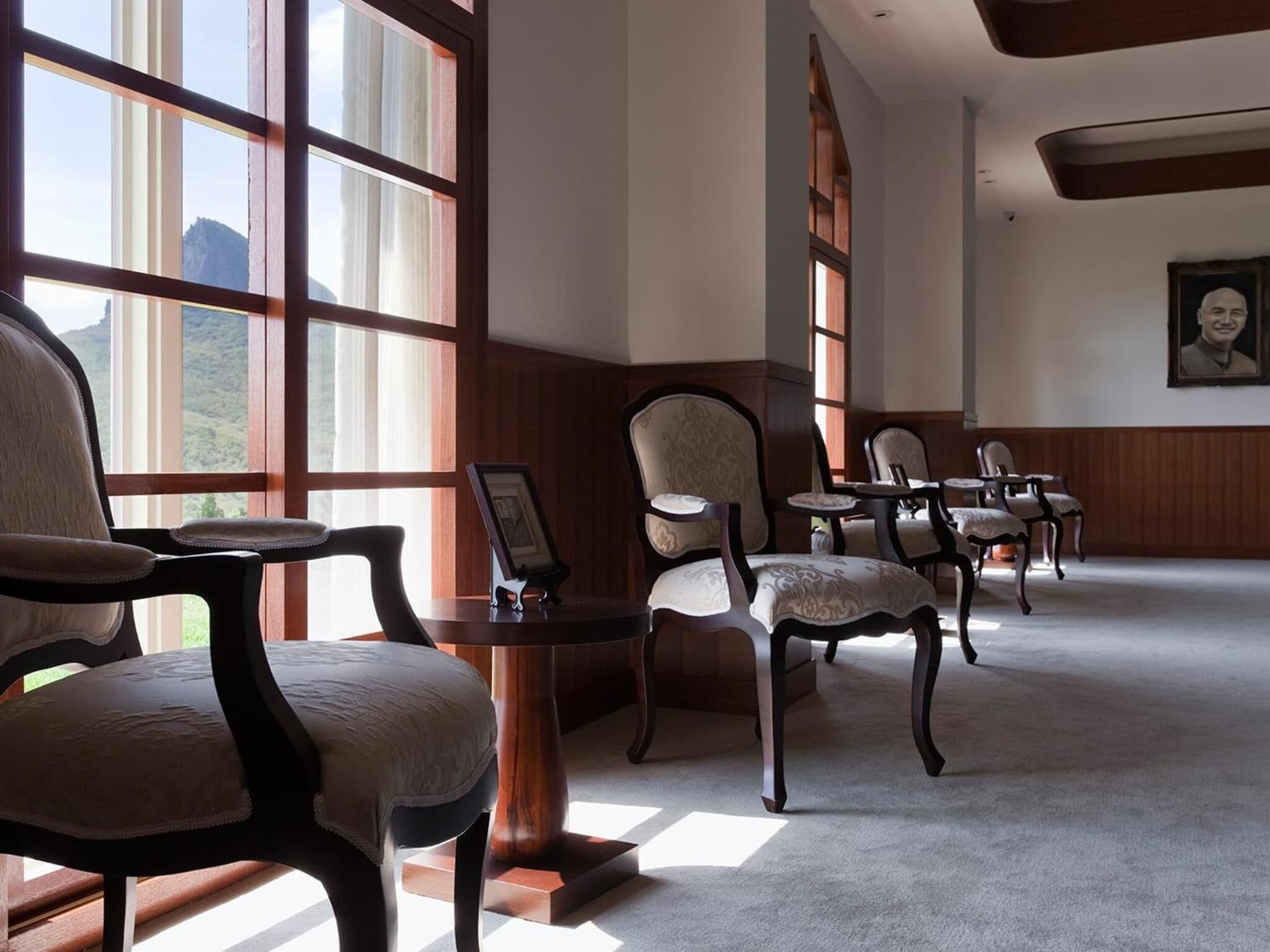 A room with large windows, wooden paneled walls, and a carpeted floor.