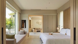Un dormitorio moderno con dos camas, un sofá y una zona de comedor con vistas.