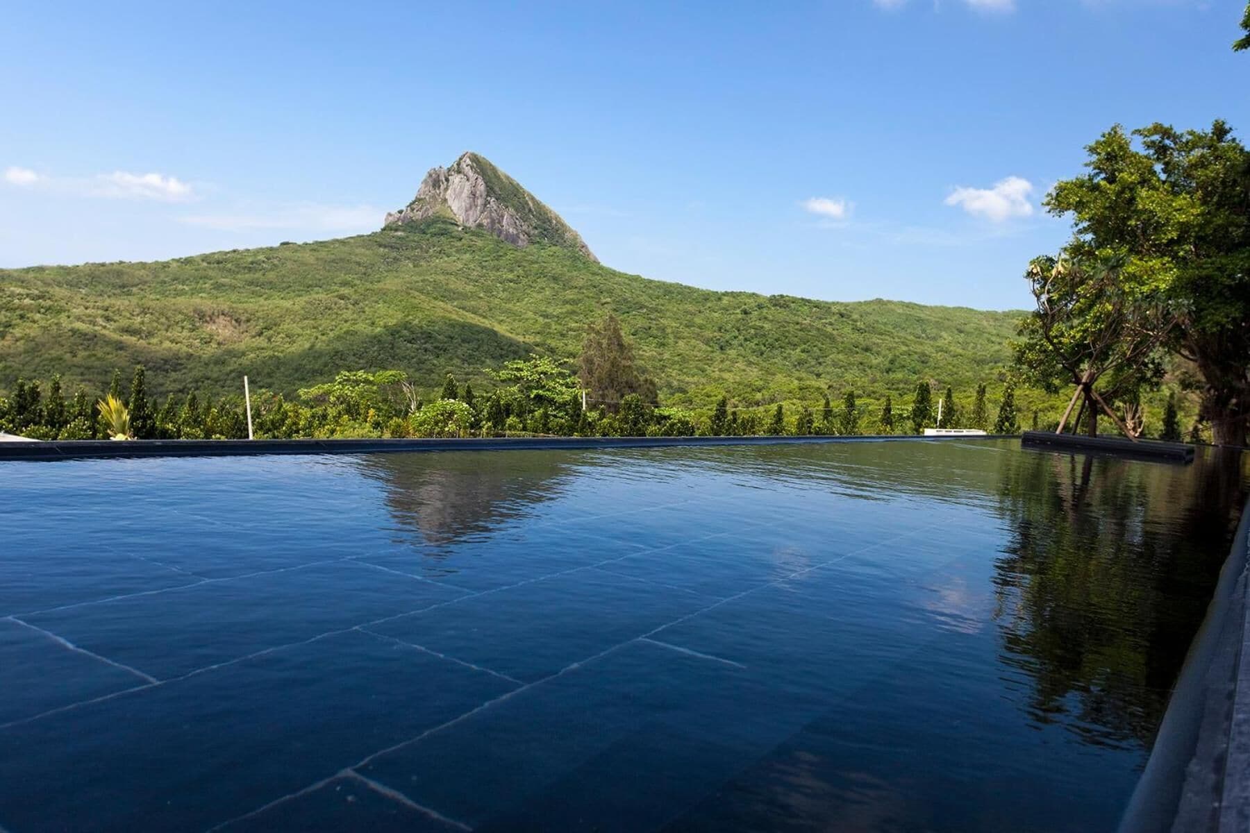 A swimming pool with a mountain in the background.