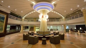 A spacious lobby with a central seating area, a high ceiling with a circular light fixture, and a balcony with railings. - Fullon Resort Kending (Hengchun)