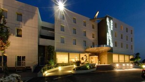 Un hôtel moderne doté d’une entrée imposante, de plusieurs étages et d’une façade bien éclairée.