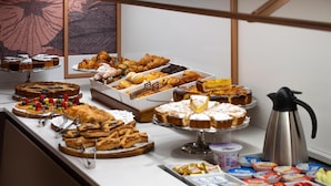 Un buffet proposant une variété de viennoiseries, de desserts et de fruits.