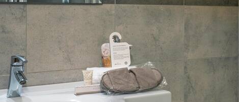 A bathroom sink with a towel, a basket, and a card.