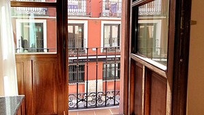 A narrow corridor with wooden doors leading to a balcony with a wrought iron railing. - Hotel Imperial (Valladolid)